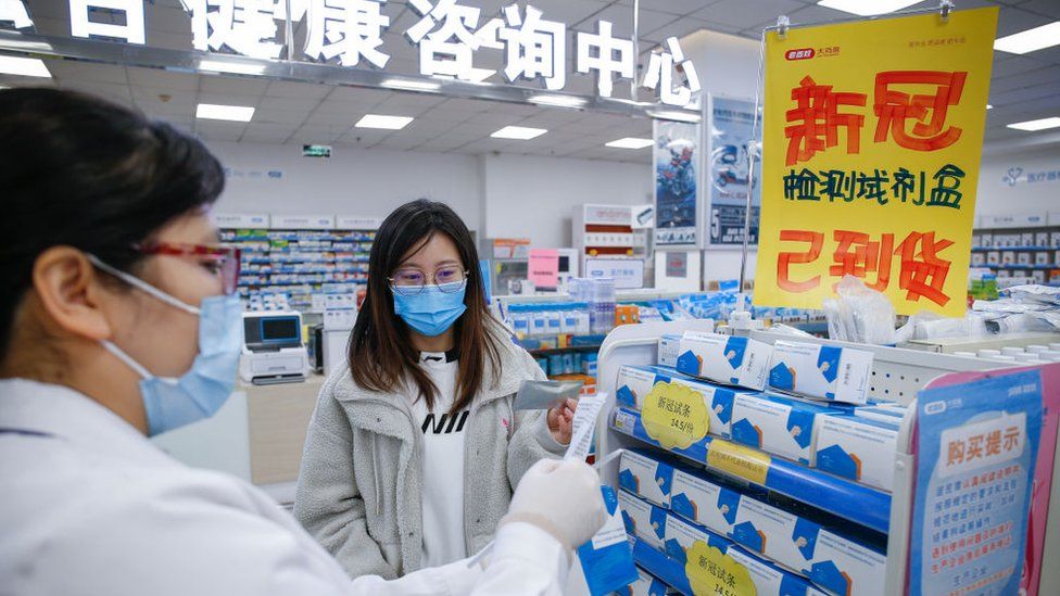 A saleswoman introduces coronavirus antigen detection kits in a drug store in Tianjin