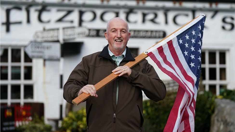 John Owen Finegan waves a US flag outside a bar in County Louth
