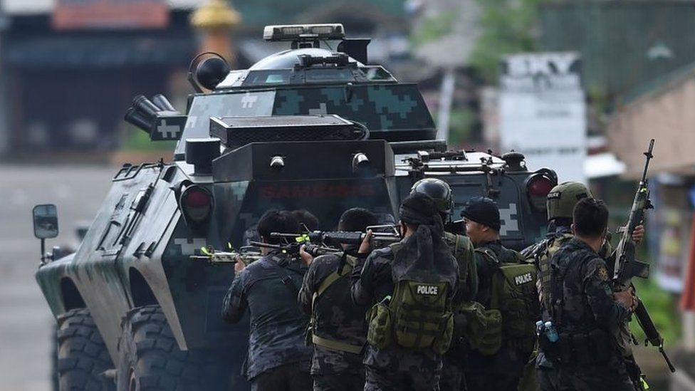 Members of the police special forces manoeuvre as they assault Muslim militants" hide out near the city hall in Marawi (28 May 2017)