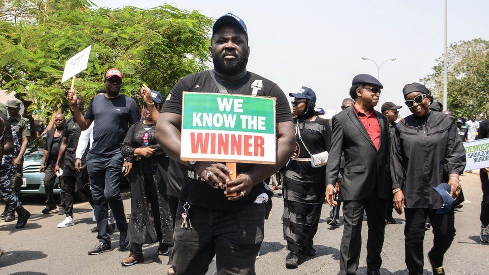 Supporters of the People's Democratic Party (PDP) display placard during a protest at Independent National Electoral Commission (INEC), protesting on the outcome of the February 25th presidential election and general election in Abuja