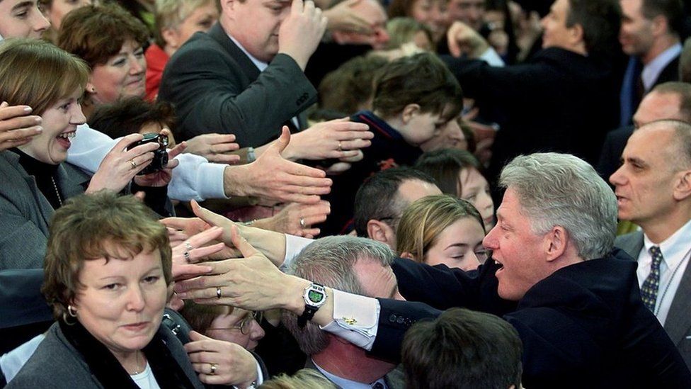 US President Bill Clinton shakes hands with local residents after addressing the people of Northern Ireland in the Odyssey Arena 13 December 2000 in Belfast. President Clinton is visiting Ireland for the third time and hopes to further the peace process in the region
