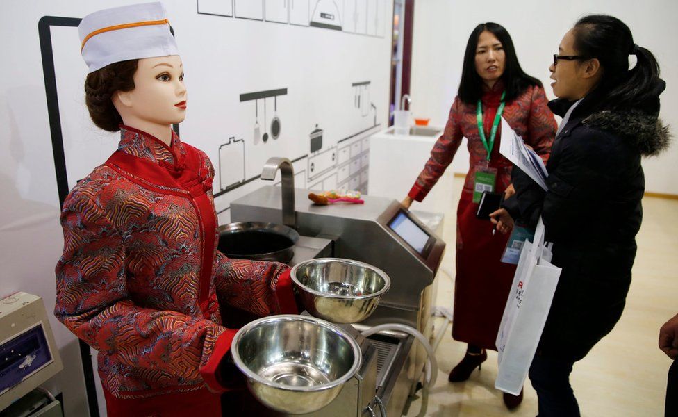 A cooking robot with the appearance of a woman is on shown during the World Robot Conference