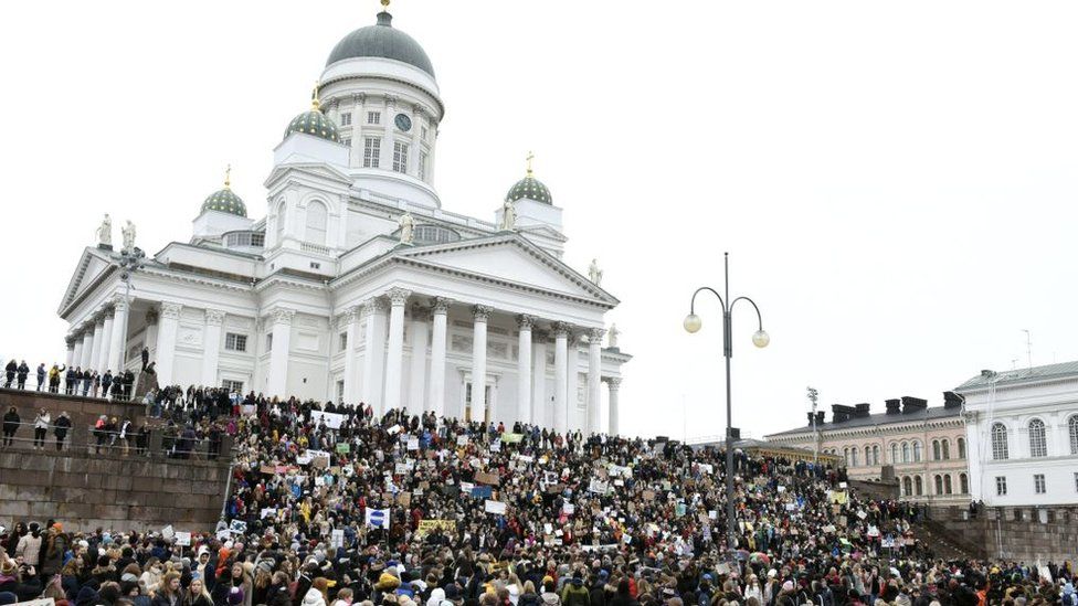 Young demonstrators gather on the steps of the Helsinki Cathedral