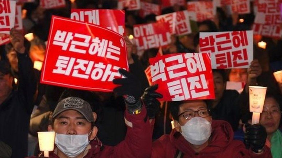 Protesters in Seoul hold banners that read: "Step down, Park Geun-hye"