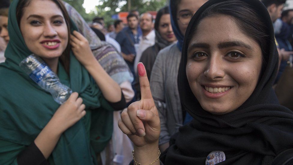 Voters show their ink-stained fingers outside a polling station for the presidential election