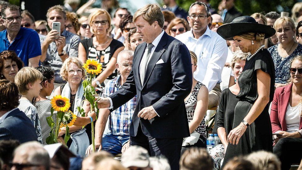 King Willem-Alexander and Queen Maxima joined families in laying sunflowers at the memorial