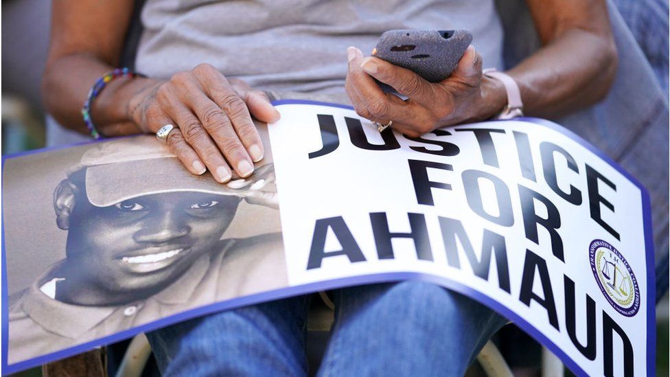 A supporter holds a Justice For Ahmaud sign