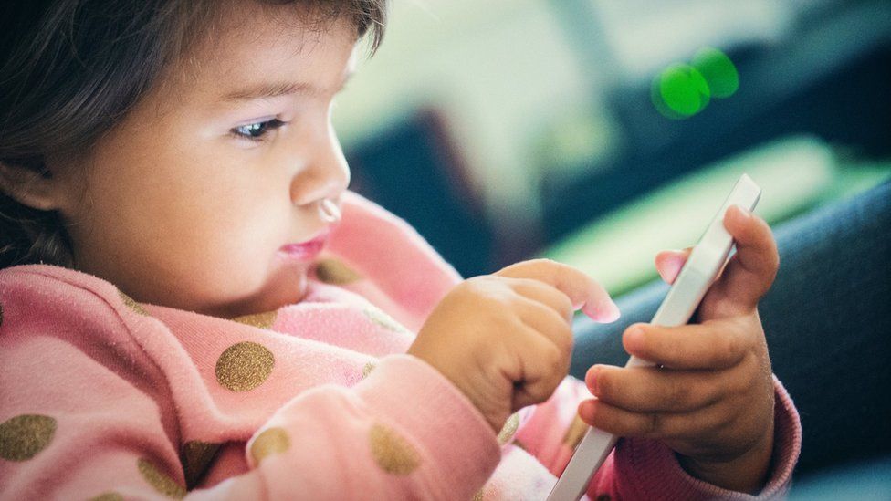 Toddler playing with smartphone
