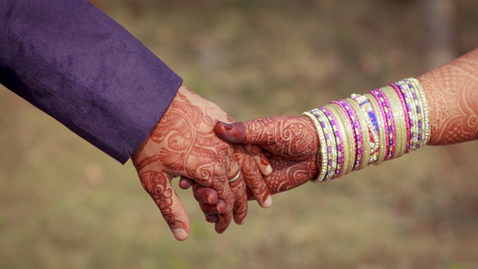 Young newly married couple holding hands - stock photo