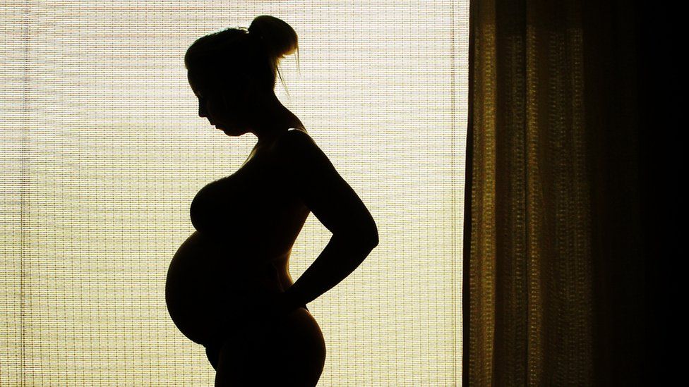 Pregnant woman by window