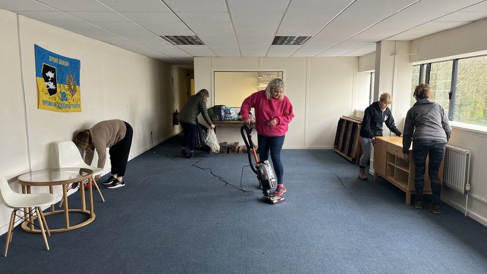 Staff from Help Ukraine BAMK preparing their new base; vacuum cleaning and moving furniture