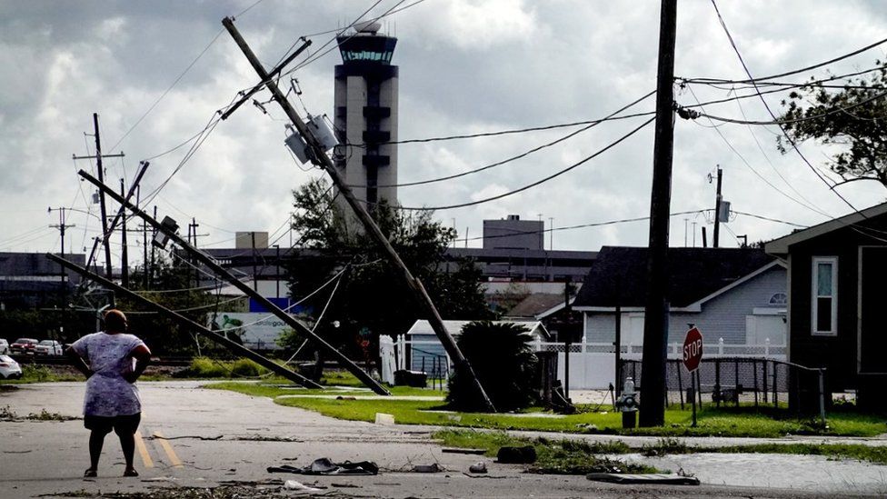 A woman looks over damage to a neighborhood caused by Hurricane Ida on August 30, 2021 in Kenner, Louisiana.