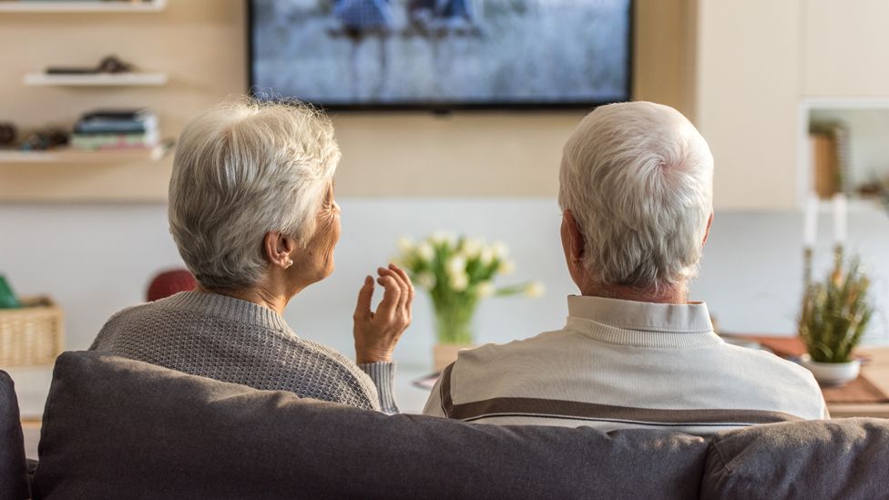 Two pensioners watching TV