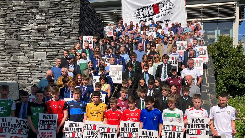 Campaigners including bereaved families, school pupils and members of GAA clubs, take part in a demonstration outside the Strule Arts Centre in Omagh