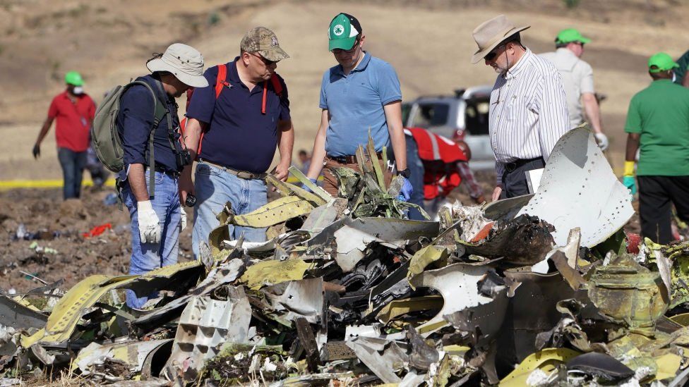 Investigators with the US National Transportation and Safety Board (NTSB) look over debris at the crash site of Ethiopian Airlines Flight ET 302.