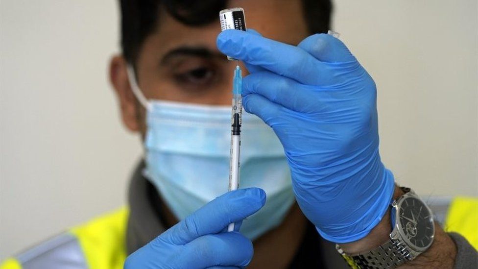 Worker prepares vaccine in Blackburn