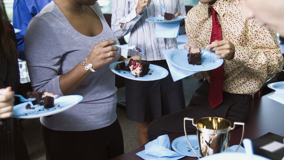 Office workers eating cake