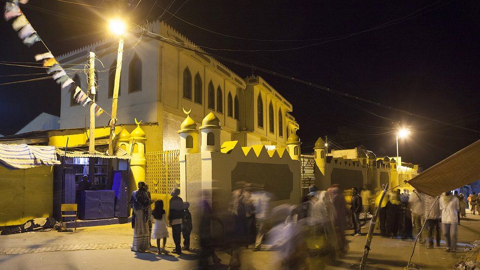 People walk in front of the Jimma Mosque, the largest mosque in Harar, especially reserved for Friday prayers, on August 3, 2014
