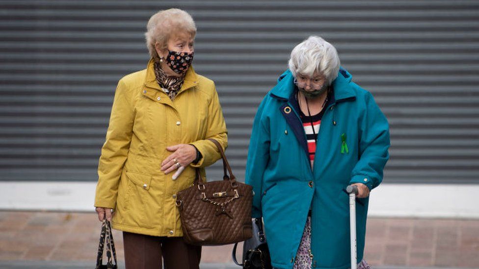 Two women wear face coverings in Merthyr Tydfil, Wales, November 2020
