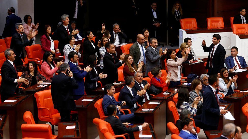 Pro-Kurdish opposition Peoples' Democratic Party MPs react after Turkey's parliament approved a bill to lift lawmakers' immunity from prosecution