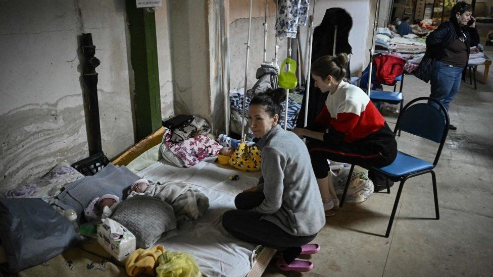 Женщины ухаживают за своими детьми в педиатрическом центре после того, как отделение было переведено в подвал больницы, который используется в качестве бомбоубежища, в Киеве, 28 февраля 2022 г.