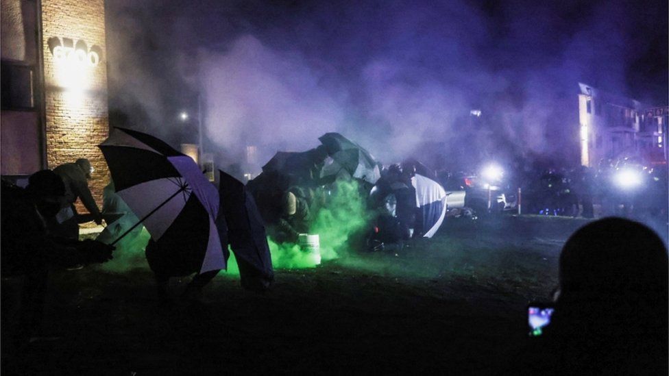 Protesters shelter from tear gas in Brooklyn Center, Minnesota, April 13, 2021