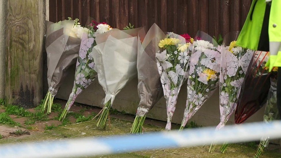 flowers laid against a wooden fence