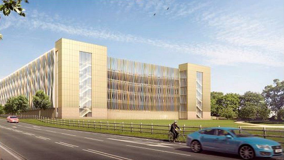 An artist's impression of the new Queen Elizabeth Hospital, a yellow multi-storey building, in King's Lynn