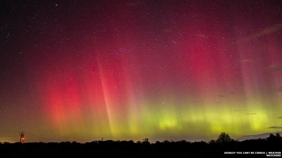 Aurora with deep reds and yellows in the night sky