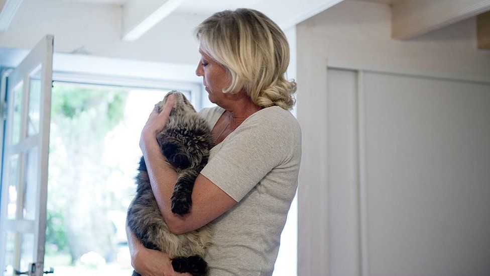 Marine Le Pen strokes her cat at her countryhouse on July 28, 2010