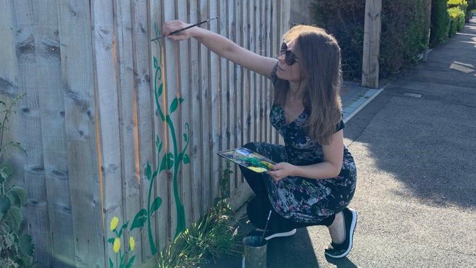 Mair Perkins painting her fence