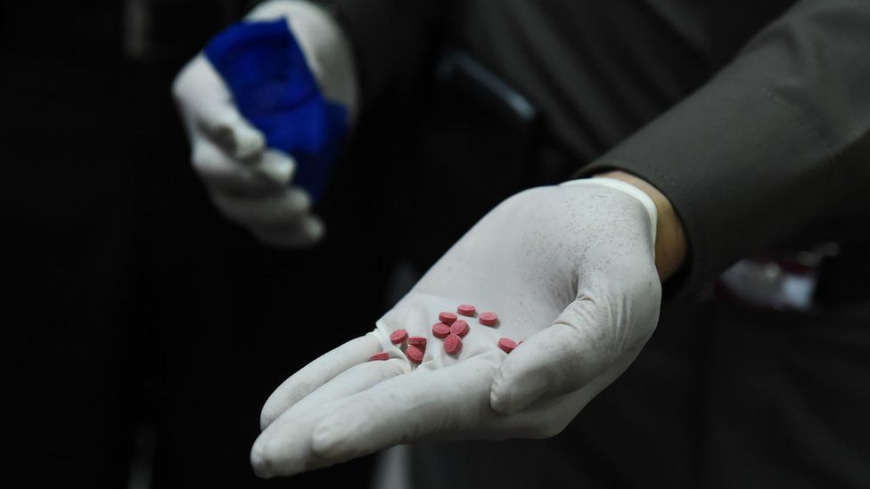 A police officer displays yaba tablets, or methamphetamine mixed with caffeine, to the media on 1 February 2017.