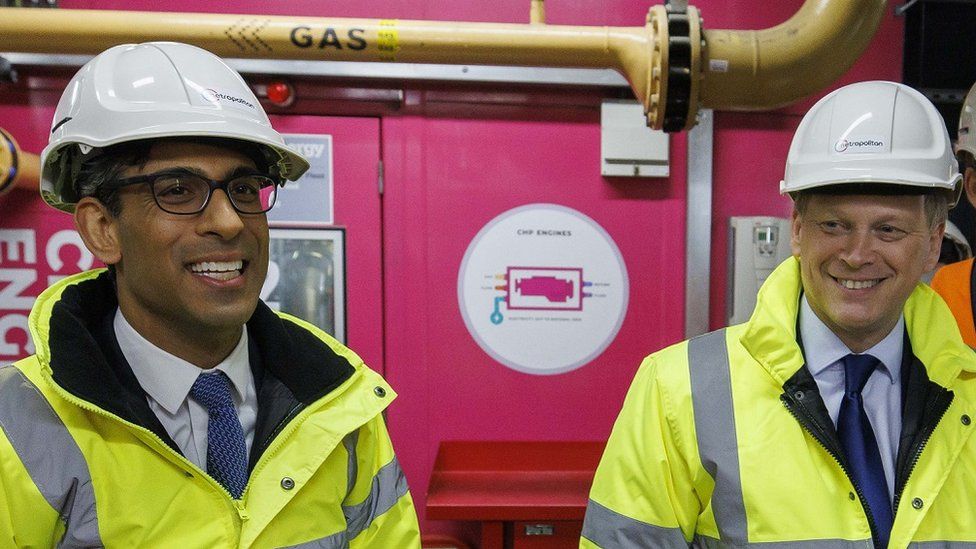 Shapps and Rishi Sunak stand side by side with hard hats on