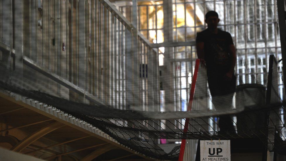 Prisoner standing at the top of a set of stairs
