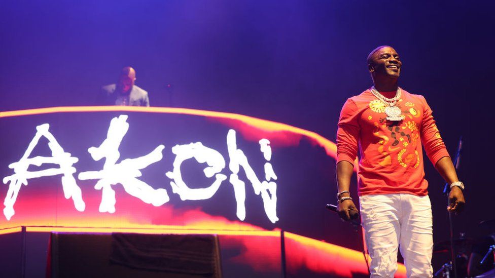 Photograph of RnB singer Akon on stage with his name in lights behind him