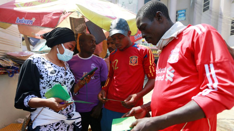 People examine their Covid vaccine cards in Abuja, Nigeria - Wednesday 26 January 2022