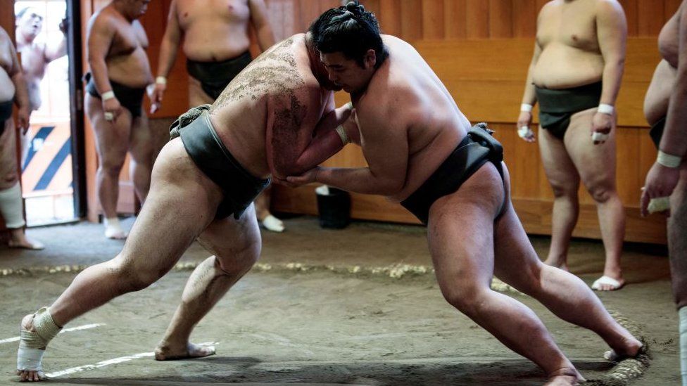 In this picture taken on August 28, 2019, sumo wrestlers try to push each other out of the ring