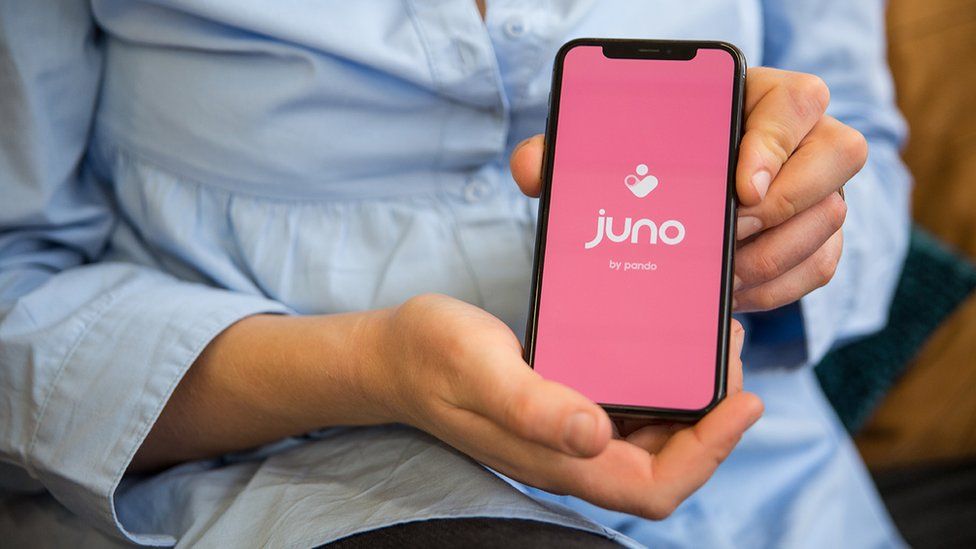 A woman holding the Juno app