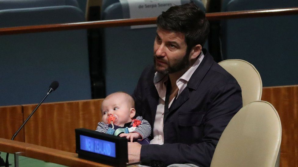 Clarke Gayford, partner to New Zealand Prime Minister Jacinda Ardern holds their baby Neve as Ardern speaks at the Nelson Mandela Peace Summit