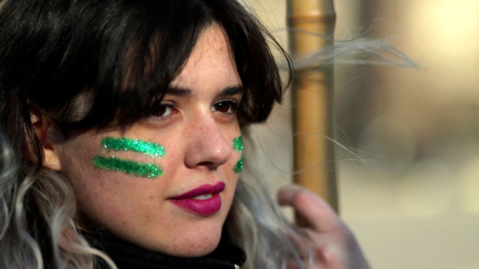 A woman with her face painted with green stripes, a colour which symbolizes the abortion rights movement, attends a demonstration in favour of legalising abortion outside the Congress in Buenos Aires, Argentina, August 1, 2018.