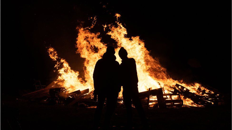 Silhouette of people in front of bonfire