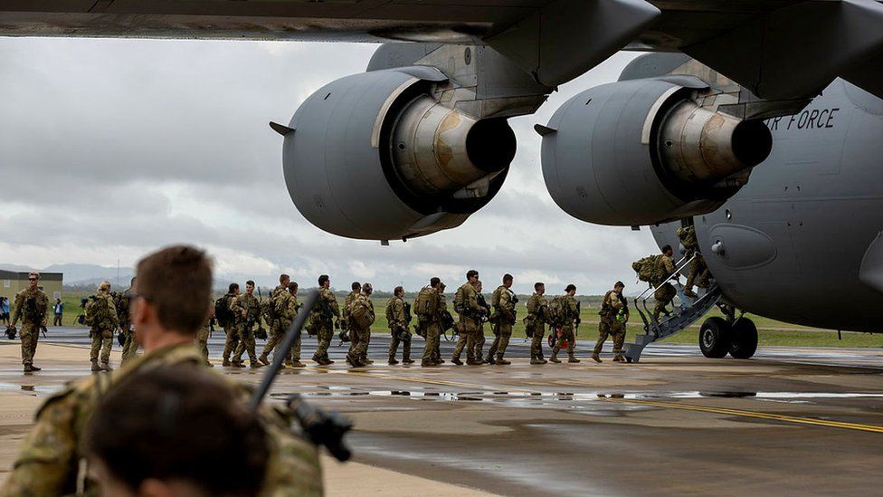 Australian soldiers queue to get on board a military aircraft headed to Solomon Islands