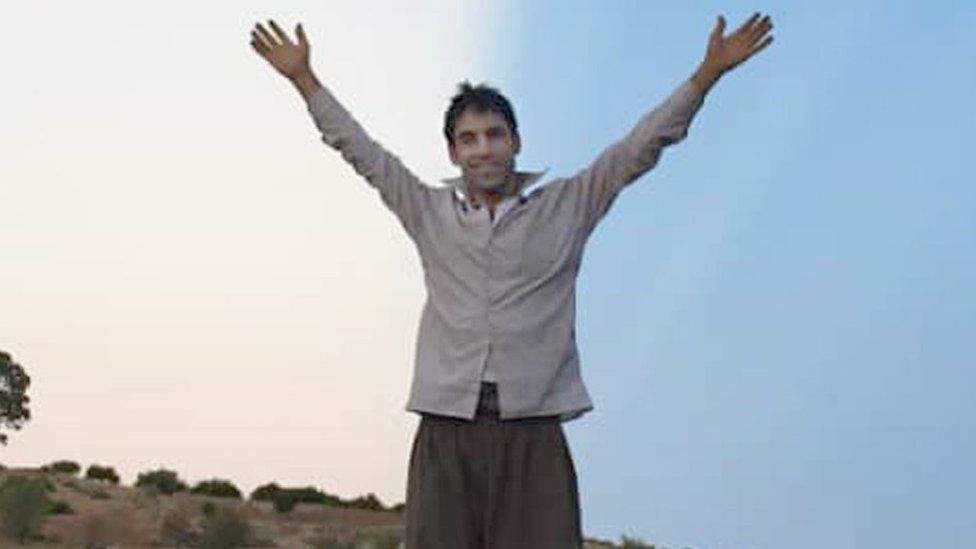 Вахид Афкари стоит на крыше автомобиля с поднятыми руками