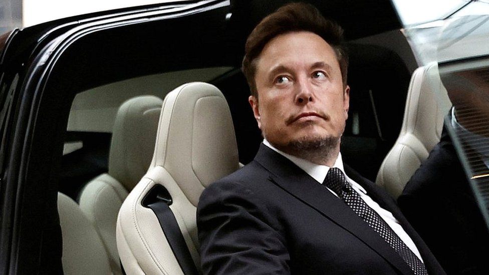 Tesla chief executive Elon Musk gets in a Tesla car as he leaves a hotel in Beijing, China.