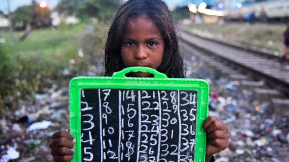 A child holds her slate board where she writes basic numbers as her lesson during a private class taken by a Kolkata police on the day of International Literacy Day in Kolkata, India, 08 September, 2021.