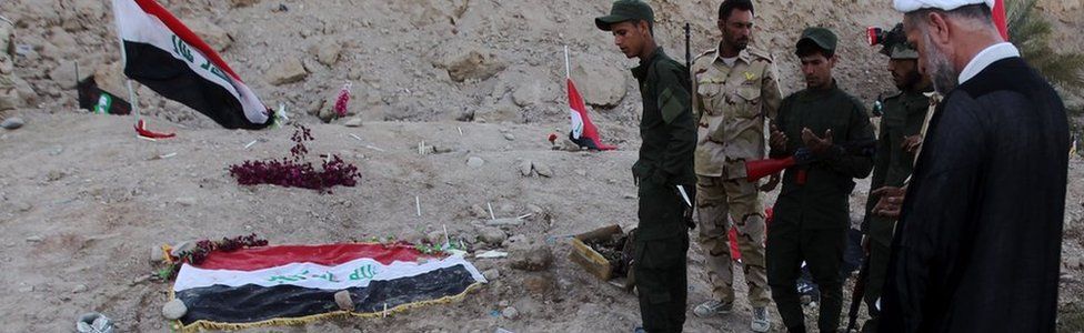 Iraqi Shia fighters examine a burial site thought to hold victims of the Camp Speicher massacre.