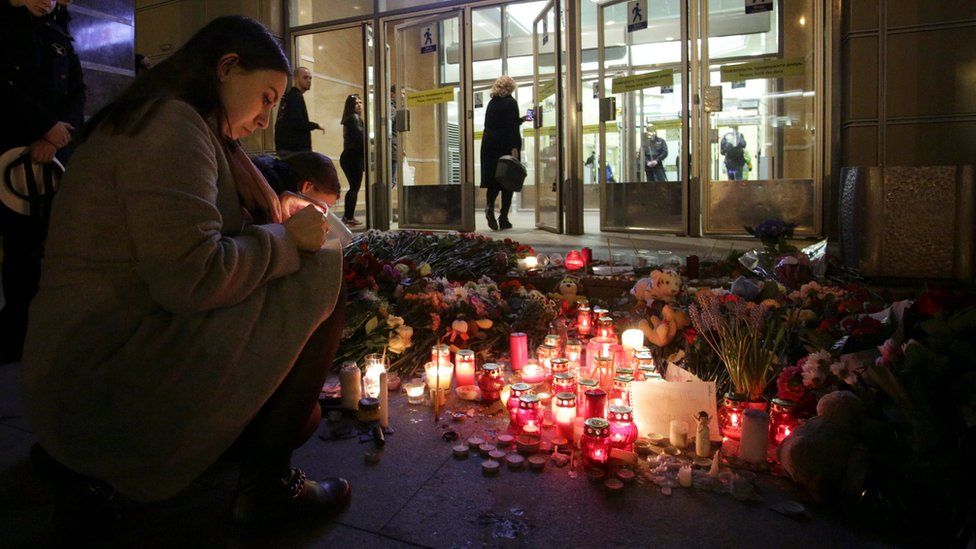 People light candles at memorial site for victims of blast in St. Petersburg metro