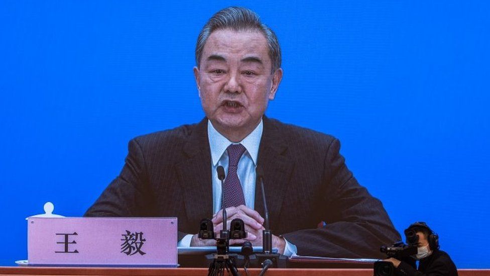 Министр иностранных дел Китая Ван И находится на экране, когда он разговаривает с журналистами во время онлайн-пресс-конференции в Пекине