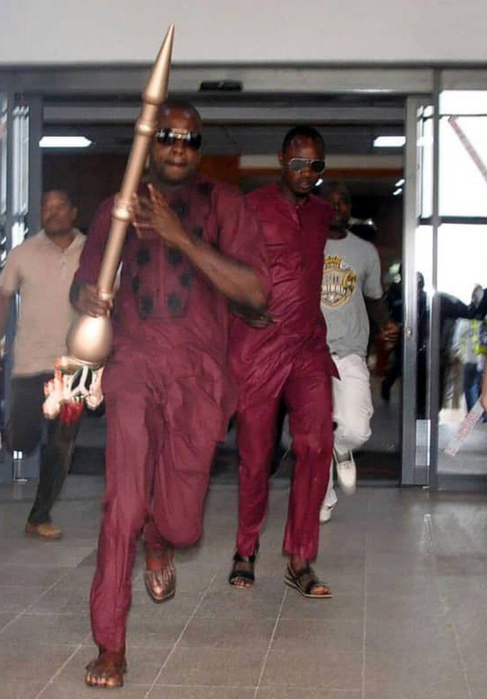 A man runs holding mace, the symbol of authority of the Upper Legislative Chamber, seized at the chamber in Abuja, on April 18, 2018. The ceremonial mace of Nigeria's upper chamber of parliament was stolen Senate leaders said, condemning the theft as an 'act of treason'.