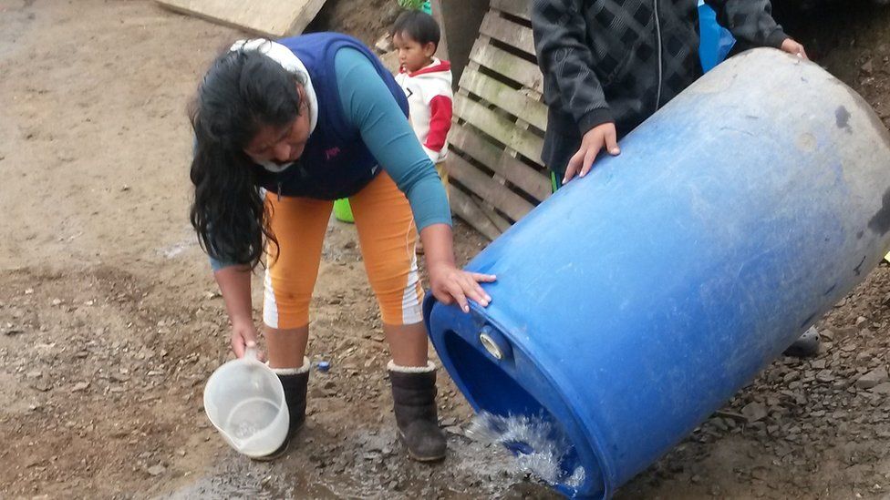 Residents of Nueva Rinconada clean out their water tanks